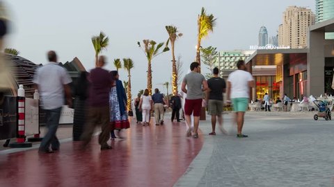 DUBAI, UAE - MARCH 27, 2014: People walking on The Walk (Jumeirah Beach Residence). The Walk is a 1.7 kilometer strip at ground level of the Jumeirah Beach Residence complex opened officially in 2008.