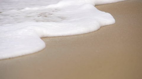 SLOW MOTION: Waves sliding along the sandy beach
