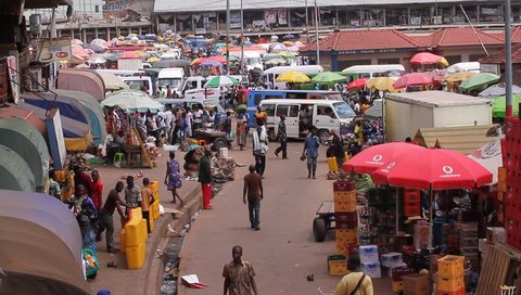 KUMASI, GHANA AFRICA  - MAY 2013, wide shot of a lorry park, market people walking 
