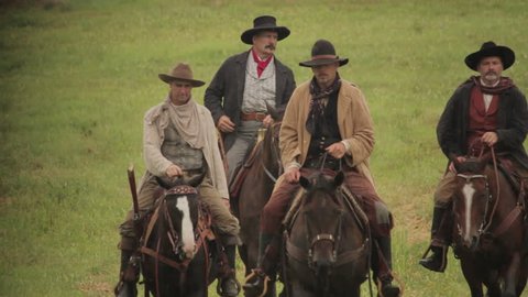 VIRGINIA - 2013.  Western era, Old West Cowboy, Marshall, Sheriff, Outlaw on horseback.  Circa 1860-1890s.  Men on horseback, galloping, riding, trot in pairs and in a group. riding in open west field