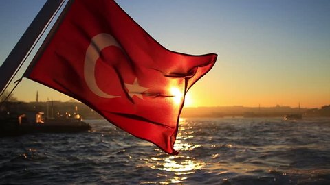 Turkish flag waving on the stern of an Istanbul Ship at sunset
