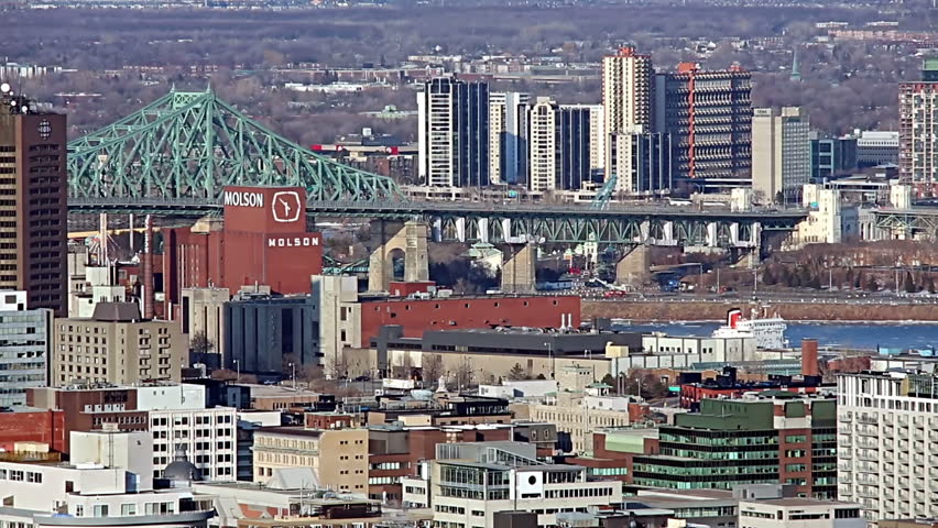 Eastern end of downtown Montreal. April 2014. Cars cross over the Jacques Cartier bridge which overlooks the Molson brewery. Condominiums stand across the St. Lawrence River in the city of Longueuil. 
