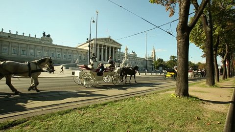 VIENNA, AUSTRIA - SEPTEMBER 2012 : Tourism industry of Europe .Horse Carriage in Vienna.Dolly shot of the several carriages with horses . Camera moves through the trees along the boulevard