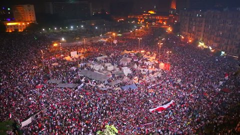 Fireworks go off above protestors gathered in Tahrir Square in Cairo, Egypt at a large nighttime rally.
