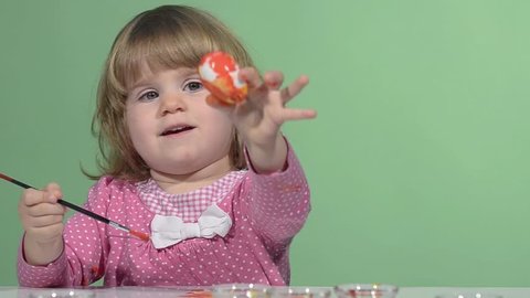 Little girl painting easter eggs