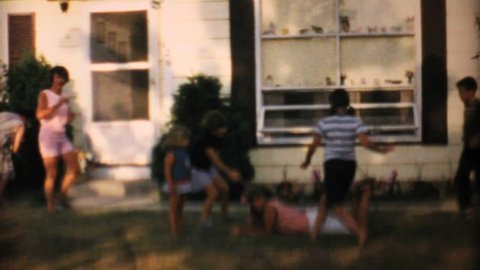 MIAMI, FLORIDA, 1967: Children play with their Grandmother on the front lawn in the summer of 1967.