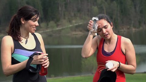 Close Up Of Two Tired Runners Stopping For A Drink In Slow Motion