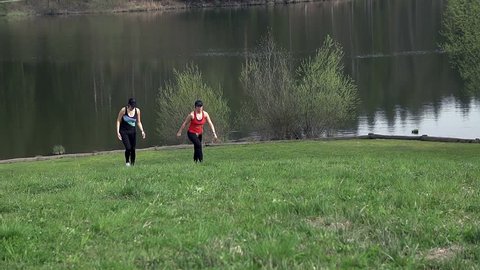 Two Attractive Woman Walking Uphill At Lake In Slow motion
