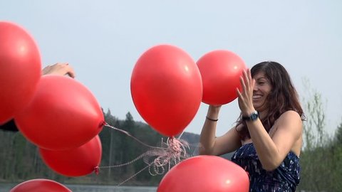 Close Up of Girls Playing With Red Balloons in Slow motion