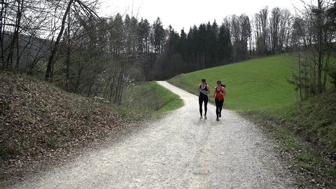 Two Fit Girls Running In Front Of Camera And Stopping