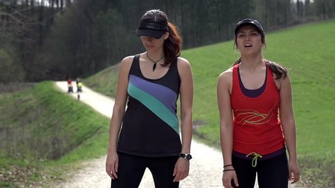 Two Female Joggers Looking At Timing And Running Afterwards