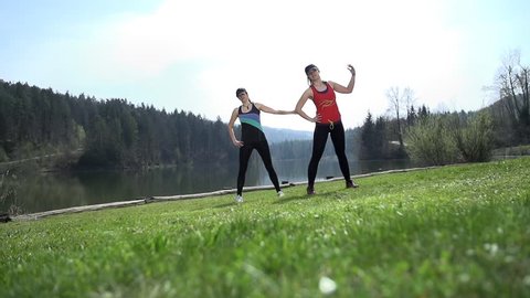 Slow Motion Two Fit Friends Doing Stretching At Lake
