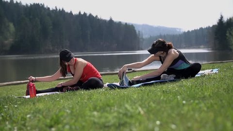 Two Women Doing Stretching At Beautiful Lake in Slow motion