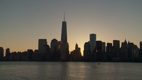(Timelapse) The sun rises behind the Freedom Tower and the buildings of the World Trade Center complex, as morning twilight transitions to day over the skyline of lower Manhattan in New York City.