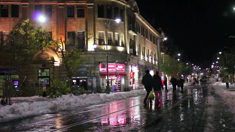 JERUSALEM, CIRCA 2013 - People walk through unusually snowy streets in Jerusalem at night.
