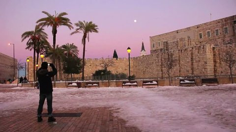 JERUSALEM, CIRCA 2013 - A man stands in a square in Jerusalem at dusk following a rare snow fall.