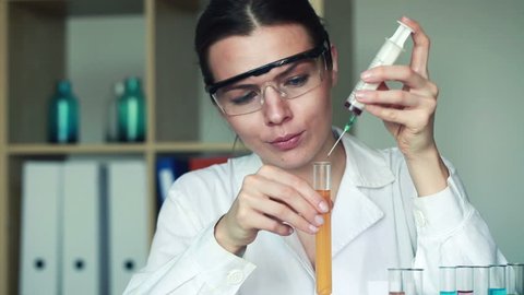 Young female chemist doing science experiment with chemicals
