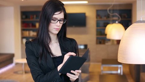 Business woman in glasses stands and takes notes in notepad