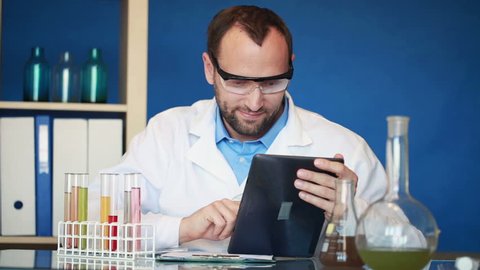 Portrait of young happy scientist with tablet computer in laboratory
