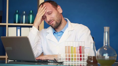 Scientist having headache during work in laboratory
