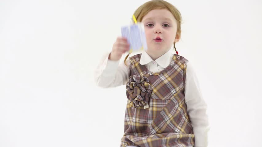 Little beautiful girl shows an empty box of juice in white studio