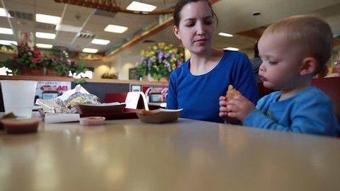 A family eating hamburgers and chicken fingers at a fast food restaurant