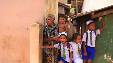 Hambantota, Asia, Sri Lanka, in November 2013. Poor neighborhoods. Large family looking at ulitsu.malchiki girl and her grandmother.