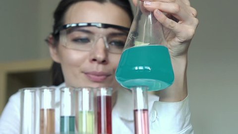 Female scientist mixing chemicals in erlenmeyer flask
