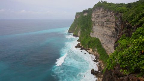 Waves of the Indian Ocean break about coastal rocks. Bali. Indonesia