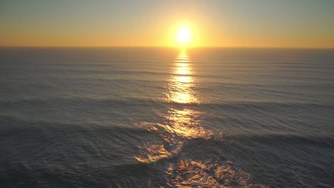 AERIAL: Flying over the ocean cliffs at sunset