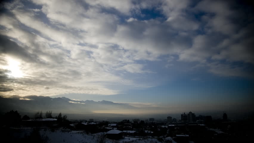 Wide Shot Time lapse Clouds over rooftops at sunrise / Salt Lake City, Utah, USA