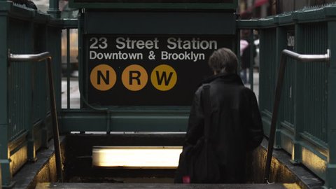 Medium Shot Rear view of person descending subway station steps at Manhattan, New York City, New York, USA