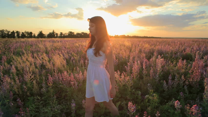 Young girl walking in the lavender field at sunset. | Shutterstock HD Video #6095453