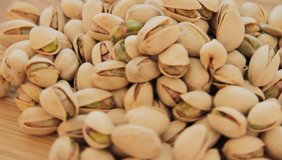 Roasted pistachios rotate on Wood Plate, video