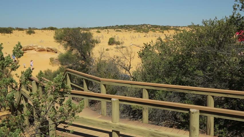 Woman tourist walks along boardwalk as she visits The pinnacles, Nambung National Park, Cervantes, Australia