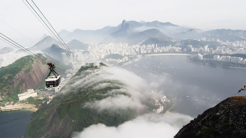 Pan of a gondola ride on a misty day over the Brazilian coastline in Rio de