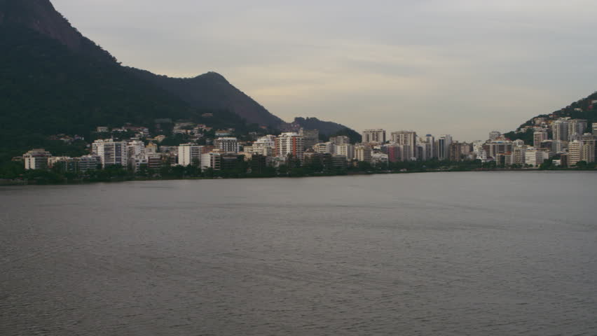 Aerial pan of lake and regional mountain geography - Rio de Janeiro, Brazil.