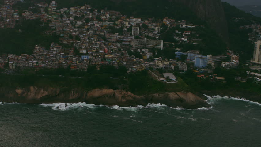 Aerial shot from shoreline cliffs to rio de janerio city.