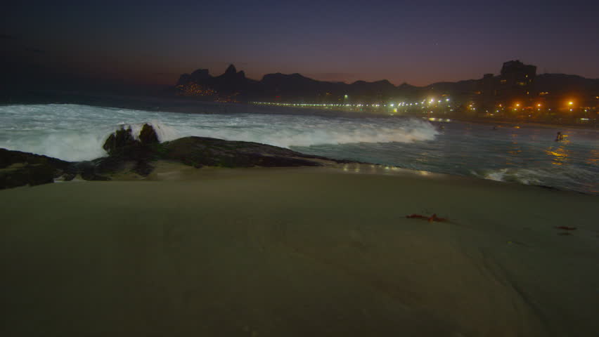 Slow motion, pan left of the waves flowing in at Ipanema beach