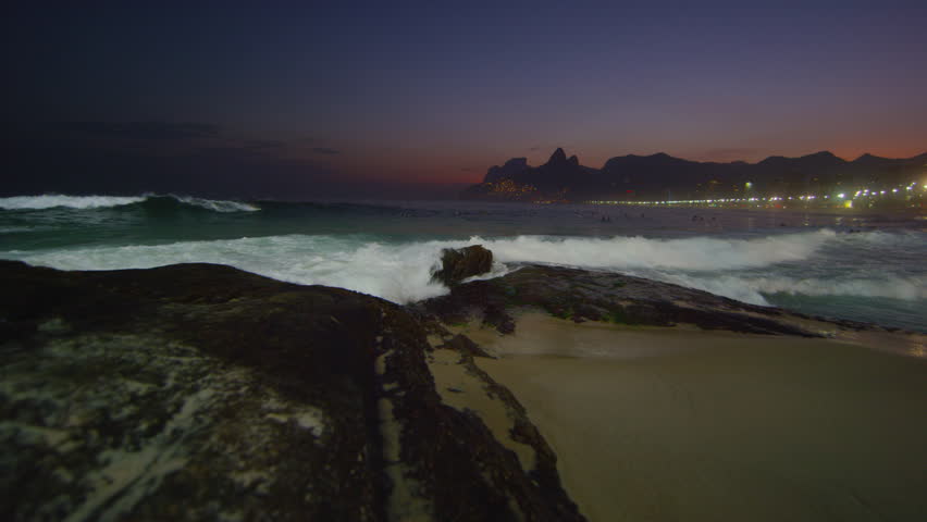 Slow motion tracking shot of the ocean flowing in against the Arpoador Rocks