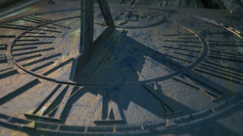 A macro panning closeup of a sundial in a twelve hour time-lapse going from morning until night