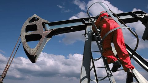 Oil Rig Worker. Pump jack with oil worker over a blue sky . 
Oil and gas. Drilling rig. Drilling worker.