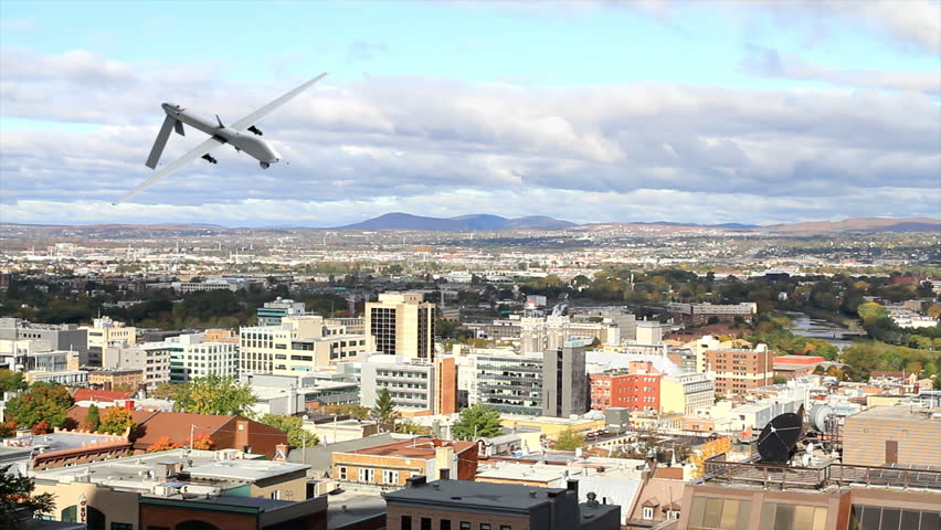 A Predator Drone flying over a large city.