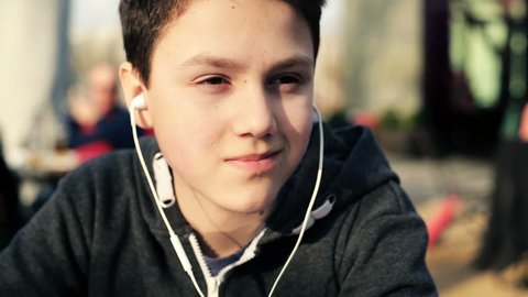 Young teenager with earphones listening to the music
