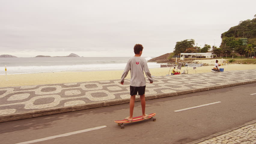 RIO DE JANEIRO, BRAZIL - JUNE 23: Slow dolly shot of skateboard boy at Ipanema