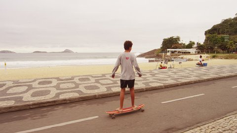 RIO DE JANEIRO, BRAZIL - JUNE 23: Slow dolly shot of skateboard boy at Ipanema Jun 23, 2013 in Rio Editorial Stock Video