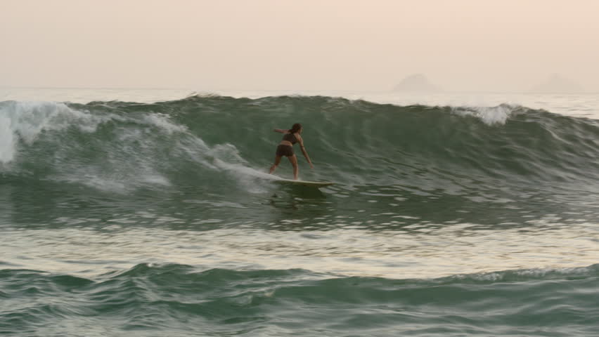 RIO DE JANEIRO, BRAZIL - JUNE: Slow motion pan shot of surfer, with large