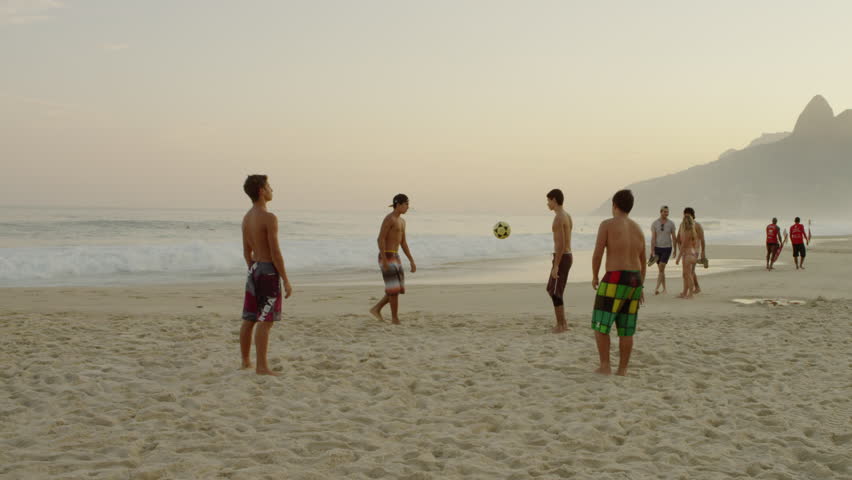 RIO DE JANEIRO, BRAZIL - JUNE 16: Teens kicking a football at the beach on June