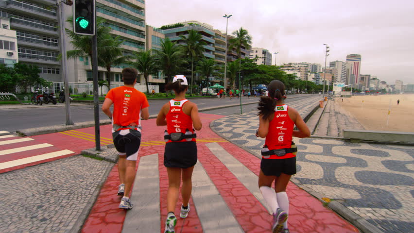 RIO DE JANEIRO, BRAZIL - JUNE: Slow tracking shot of three runners running along