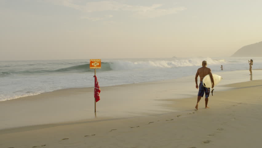 RIO DE JANEIRO, BRAZIL - JUNE: Surfer watches waves on shore